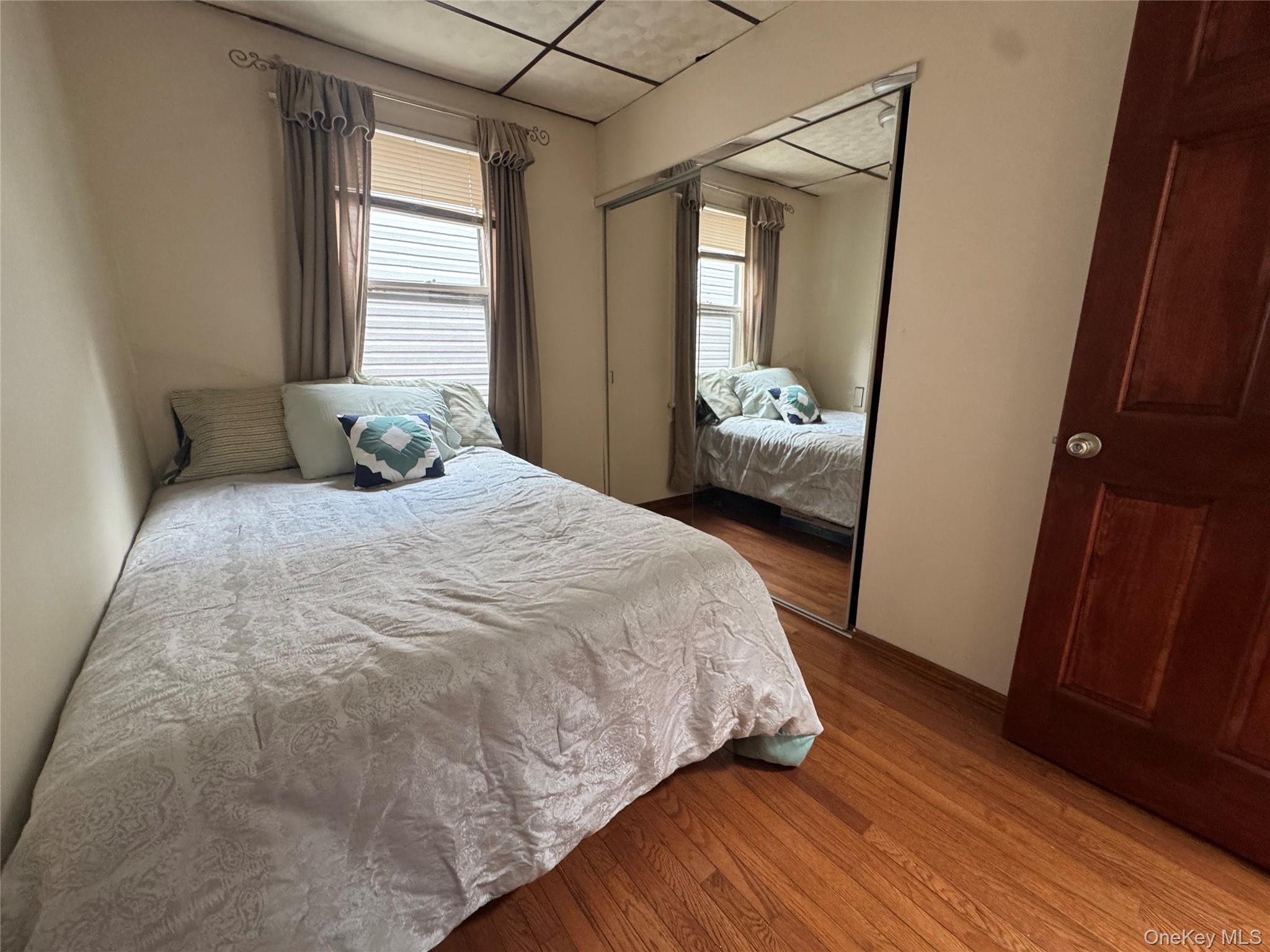 80-58 88th Road Queens, NY 11421 - Photo 15 of 21 a bedroom with a bed and a large mirror