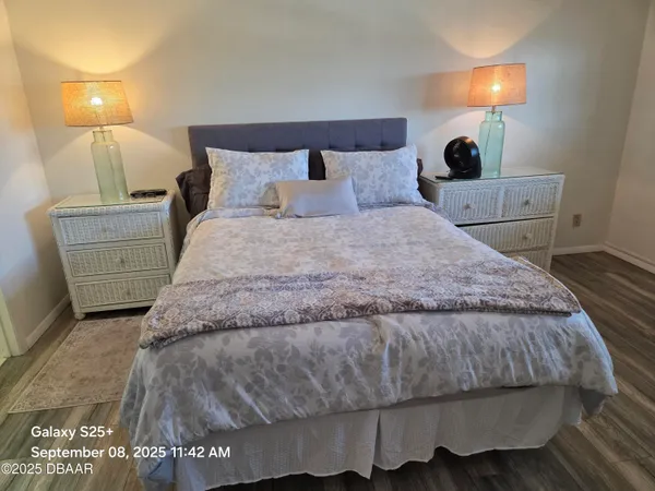 a bedroom with a bed and wooden floor