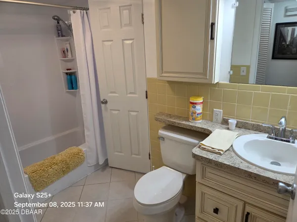 a bathroom with a granite countertop sink a toilet and a mirror