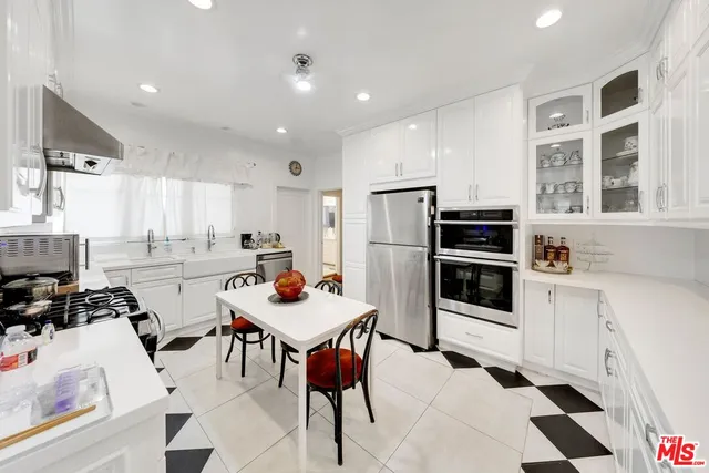a kitchen with a refrigerator a stove top oven a sink and cabinets