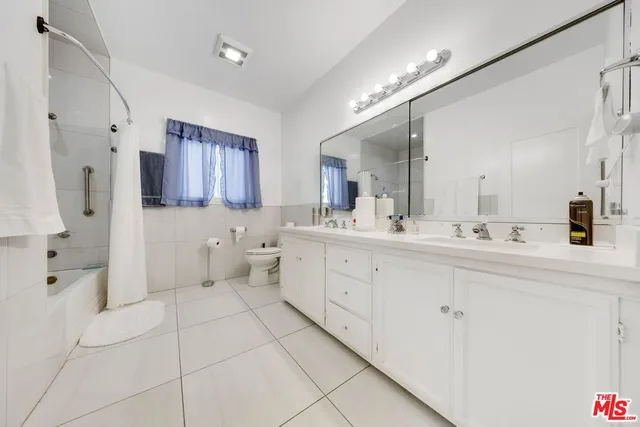 a spacious bathroom with a double vanity sink toilet and shower