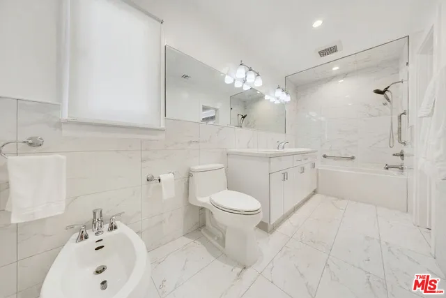 a bedroom with a bed and a refrigerator