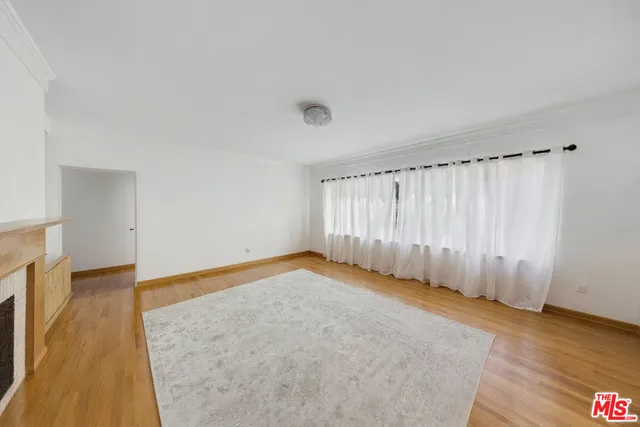 an empty room with wooden floor and fireplace