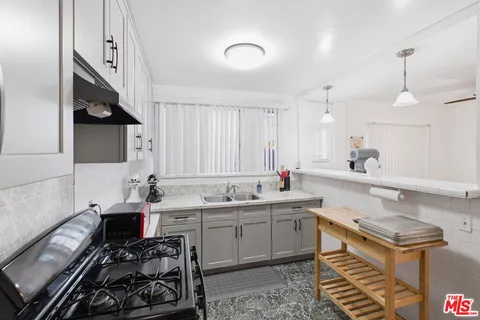a kitchen with a sink stove and cabinets