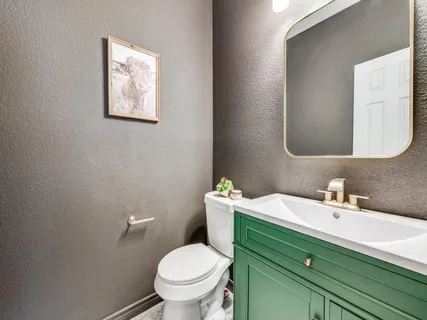 a bathroom with a toilet sink and mirror