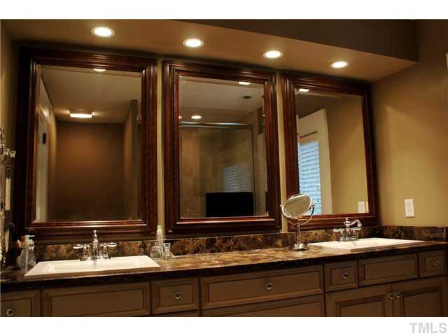 502 Cole Street Raleigh, NC 27605 - Photo 10 of 25 Master bath has gorgeous stone counters with inset china sinks and attractive decorative mirrors. In the background you can see the glass shower surround.