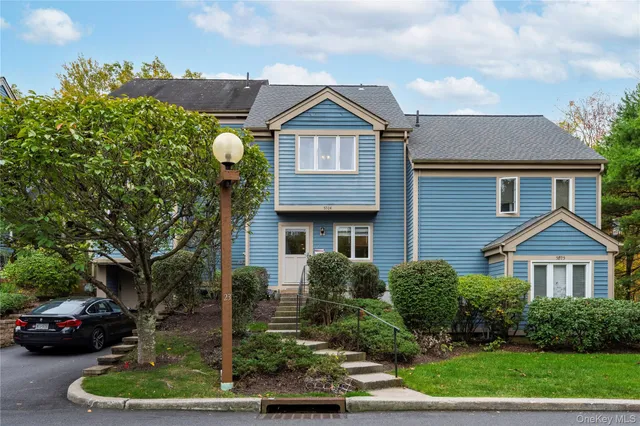 a front view of a house with a yard and potted plants