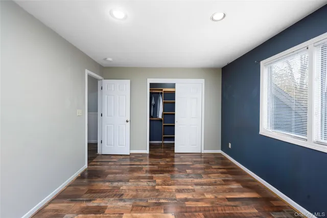 a view of a room with a window and wooden floor
