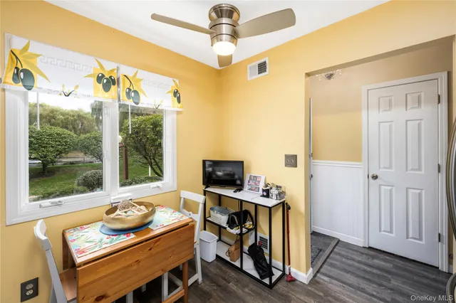 a view of a workspace with furniture and a window