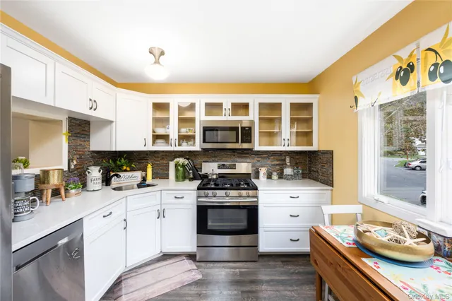 a kitchen with a stove a sink and wooden floor