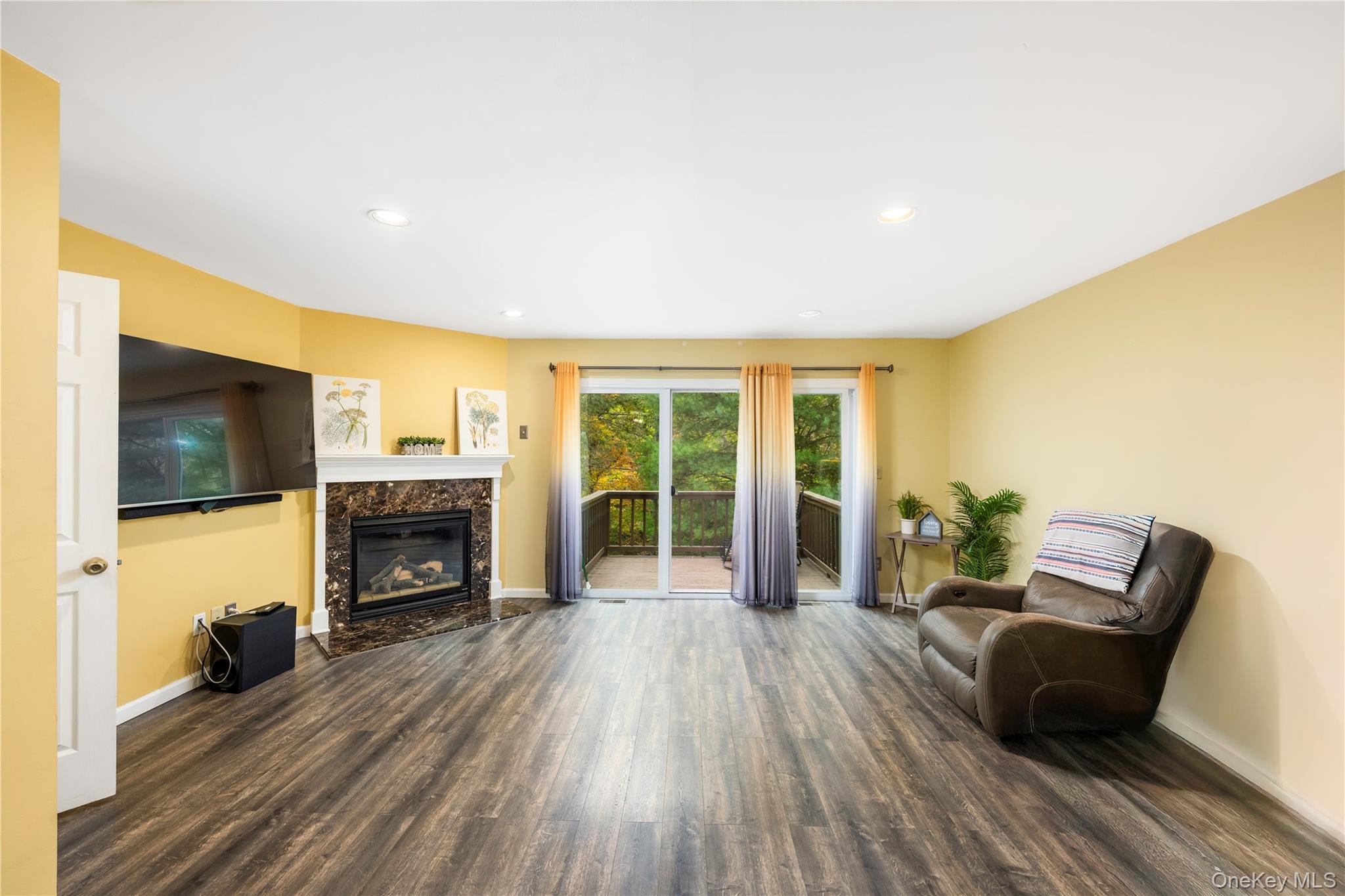 5704 Manor Drive Peekskill, NY 10566 - Photo 6 of 39 a living room with furniture floor to ceiling window and a flat screen tv