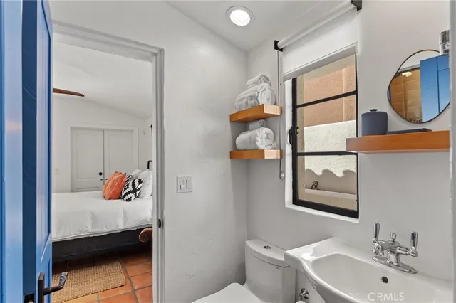 a bathroom with a sink mirror and toilet