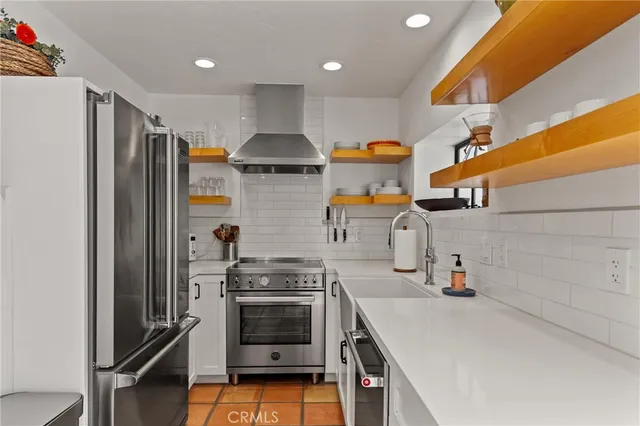 a kitchen with stainless steel appliances a sink stove and refrigerator