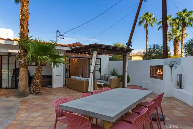 a view of a patio with table and chairs under an umbrella