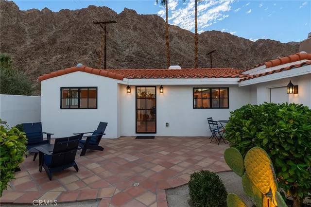 a backyard of a house with table and chairs