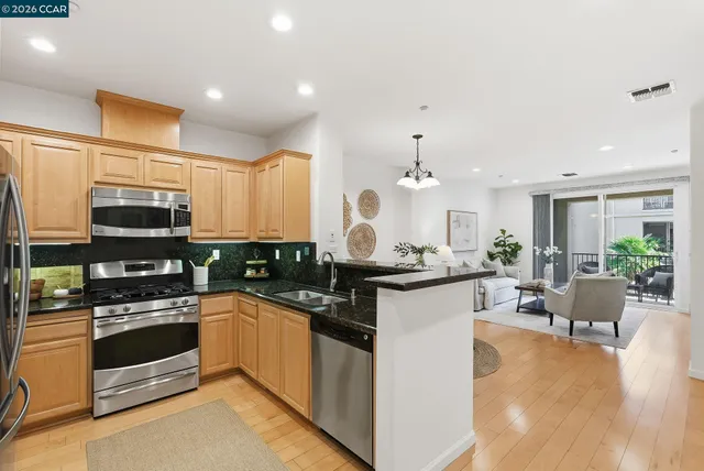 a large kitchen with stainless steel appliances kitchen island granite countertop a stove and a sink