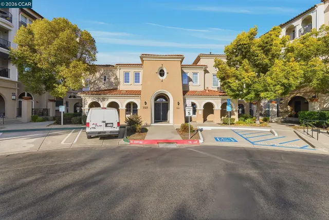 a view of a white house with a large space and a car parked in front of it