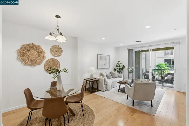 a view of a dining room and a livingroom with furniture wooden floor and a rug