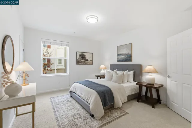 a bedroom with a bed wooden floor and a lamp