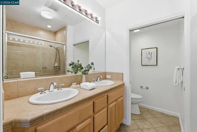 a bathroom with a granite countertop sink mirror and toilet