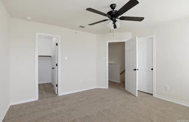 an empty room with a window and a fan