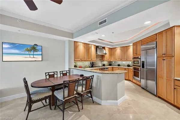 a kitchen with a table chairs refrigerator and cabinets