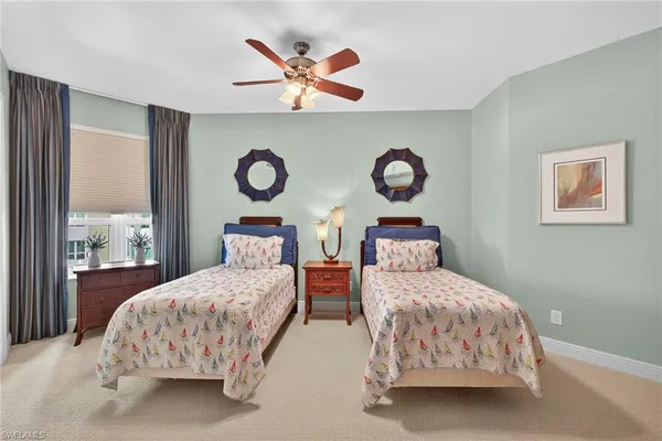 a bedroom with two beds and a painting on the wall