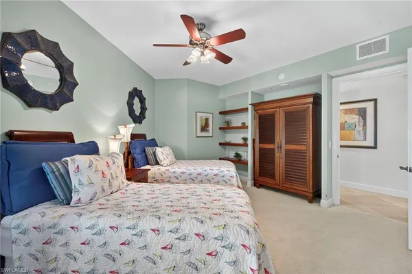 a bedroom with a large bed and a chandelier