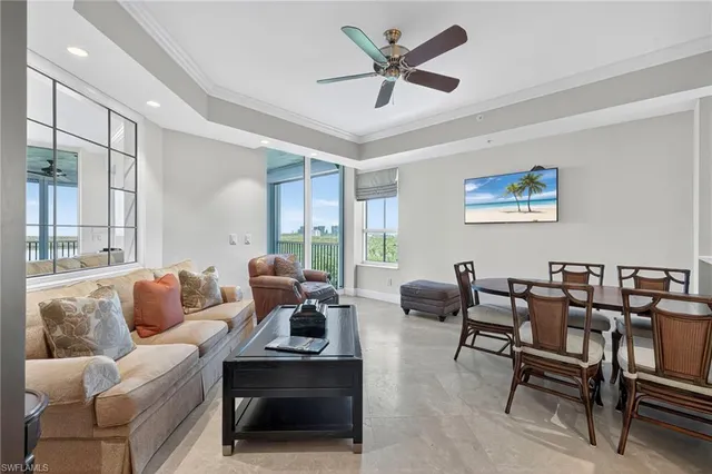 a living room with furniture a rug potted plant and a window