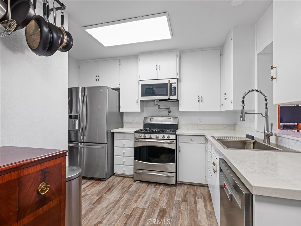 14060 Osage Road Apple Valley, CA 92307 - Photo 11 of 39 a kitchen with stainless steel appliances a stove a sink and a refrigerator