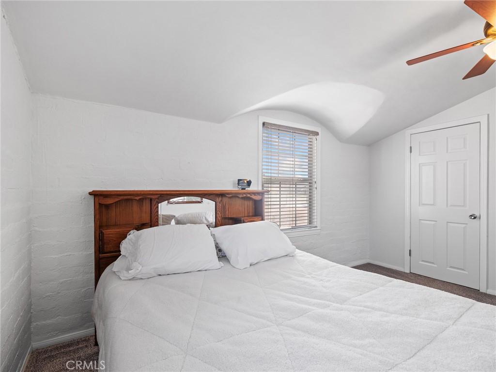 14060 Osage Road Apple Valley, CA 92307 - Photo 24 of 39 a large bed sitting in a bedroom next to a window and a lamp