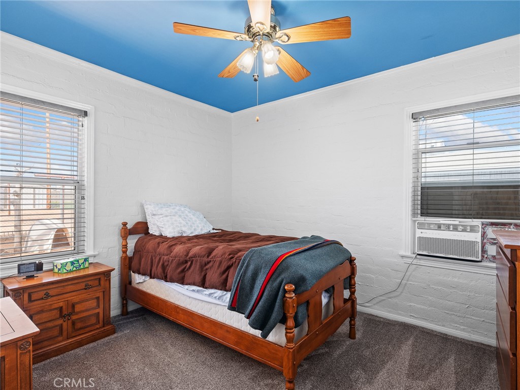 14060 Osage Road Apple Valley, CA 92307 - Photo 27 of 39 a bedroom with a bed and a chandelier