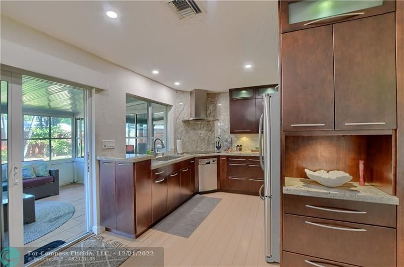 331 Southeast 4th Street Deerfield Beach, FL 33441 - Photo 10 of 37 a large kitchen with stainless steel appliances granite countertop a refrigerator and a stove top oven