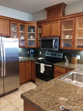 a kitchen with stainless steel appliances granite countertop a stove a sink and a microwave