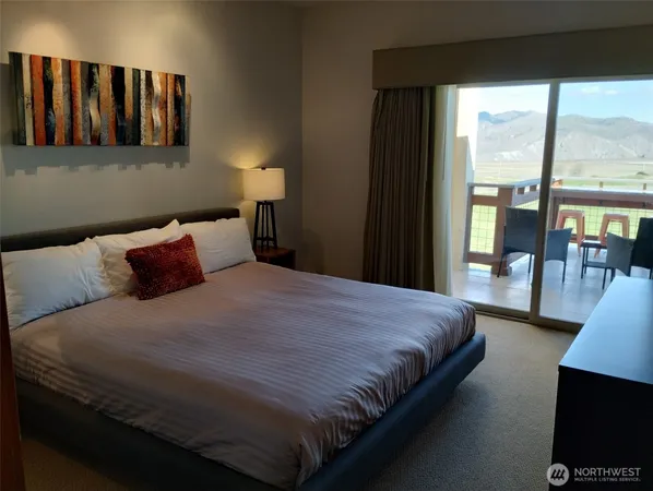 a bedroom with a bed and glass window