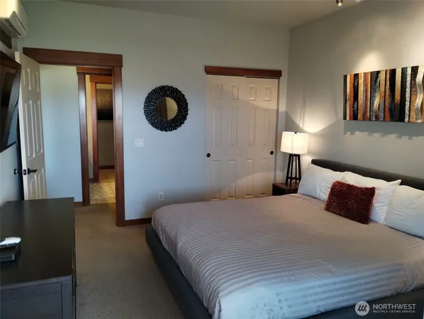 a bedroom with a bed and painting on the wall