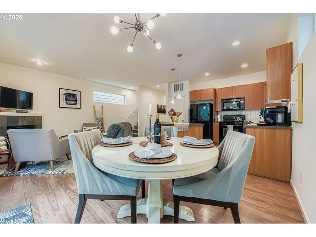 a kitchen with stainless steel appliances granite countertop a refrigerator a microwave a stove and white cabinets with wooden floor