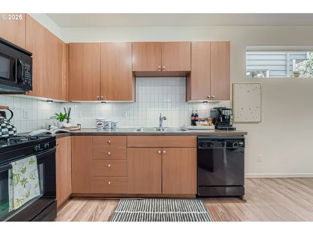 a kitchen with stainless steel appliances granite countertop a refrigerator a sink dishwasher a stove with wooden floor