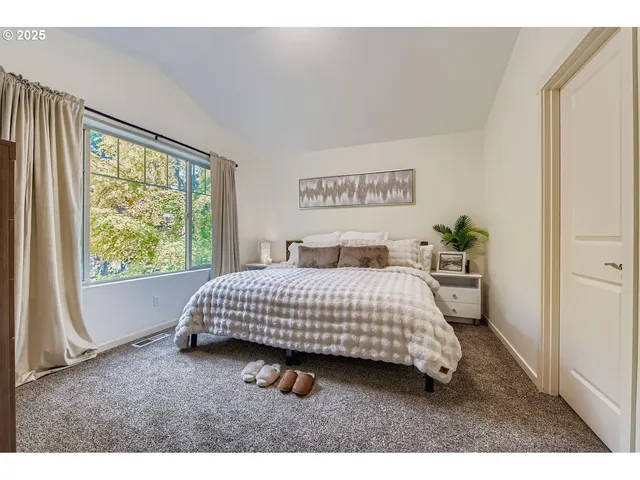 a bedroom with a bed and a large window
