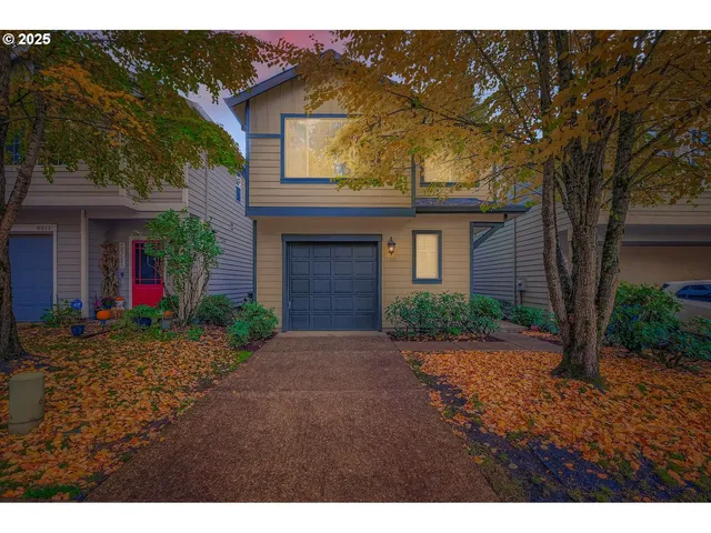 a front view of a house with a yard and a garage
