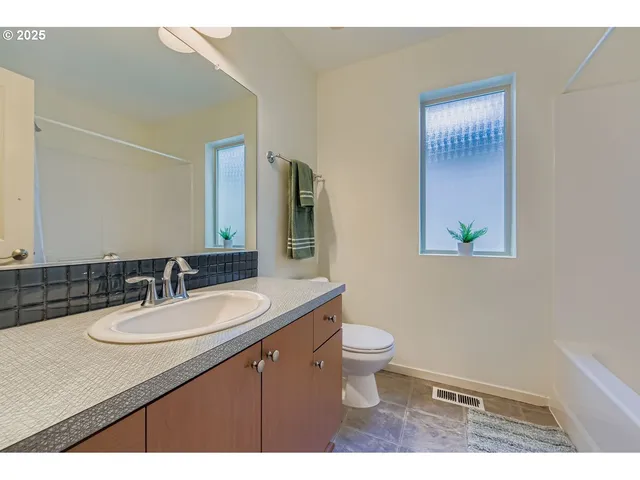a bathroom with a sink a toilet and mirror