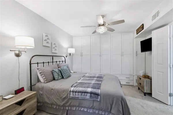 a bedroom with a bed and a flat tv screen on the dresser