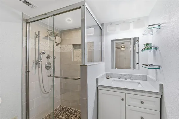 a bathroom with a shower sink and mirror