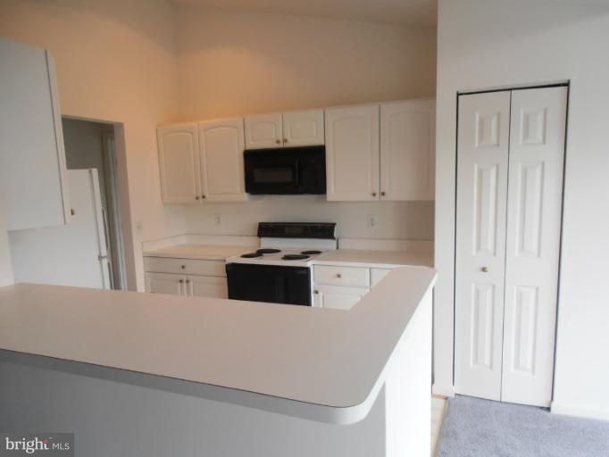 693 Winding Stream Way, Unit 302 Odenton, MD 21113 - Photo 15 of 26 a kitchen with stainless steel appliances a stove top oven a sink and a refrigerator