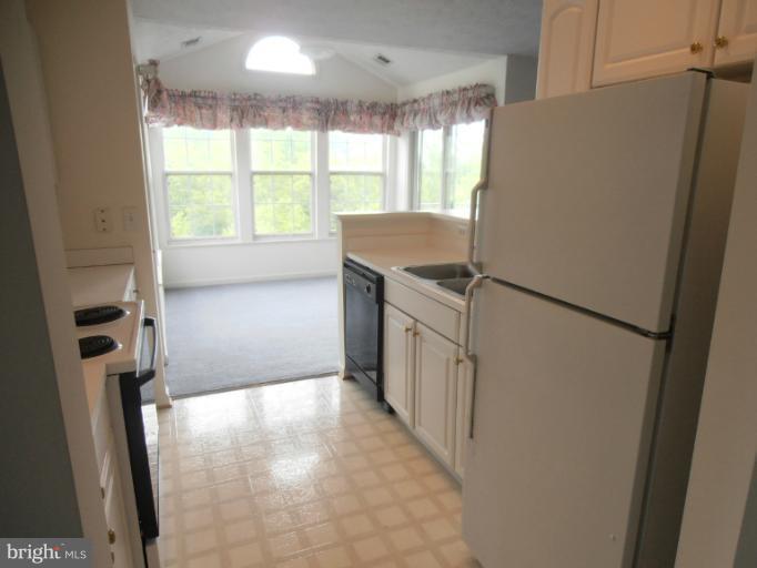 693 Winding Stream Way, Unit 302 Odenton, MD 21113 - Photo 16 of 26 a view of a kitchen with a refrigerator washer and dryer