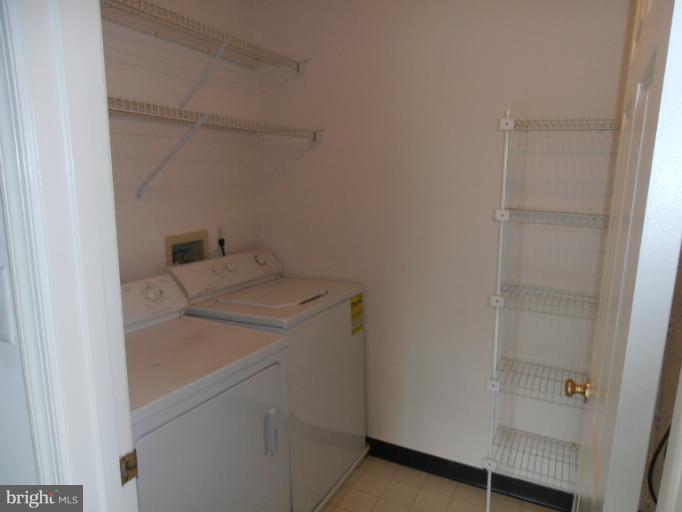 693 Winding Stream Way, Unit 302 Odenton, MD 21113 - Photo 17 of 26 a utility room with dryer and washer