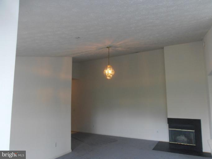 693 Winding Stream Way, Unit 302 Odenton, MD 21113 - Photo 24 of 26 a room with a fireplace and a microwave