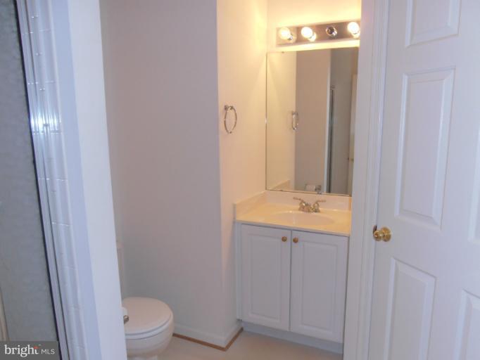 693 Winding Stream Way, Unit 302 Odenton, MD 21113 - Photo 10 of 26 a bathroom with a granite countertop sink a toilet and shower