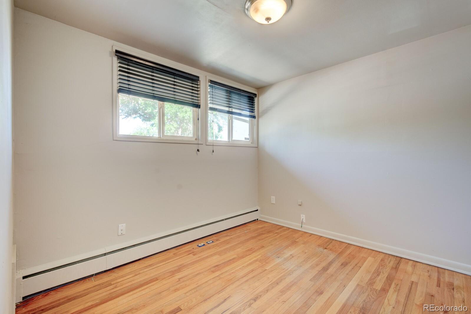 7928 Raleigh Place Westminster, CO 80030 - Photo 12 of 24 an empty room with wooden floor and windows