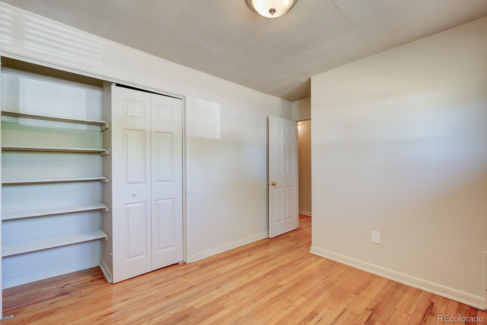 7928 Raleigh Place Westminster, CO 80030 - Photo 13 of 24 a view of an empty room with wooden floor and closet